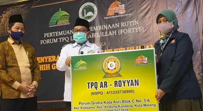 Ketua III, Yayasan Masjid Sabilillah, Prof Mas'd Said Phd, menyerahkan plakat secaa simbolis kepada kepala sekola TPQ.(foto: Istimewa)