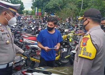Petugas melakukan pemeriksaan pada remaja yang akan mengambil motornya.(foto: Rizal Adi Pratama).