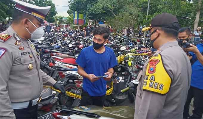 Petugas melakukan pemeriksaan pada remaja yang akan mengambil motornya.(foto: Rizal Adi Pratama).