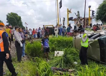 Petugas polisi saat mengamankan are kecelakaan KA dan mobil KIA.