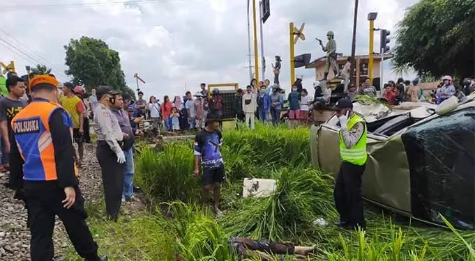 Petugas polisi saat mengamankan are kecelakaan KA dan mobil KIA.