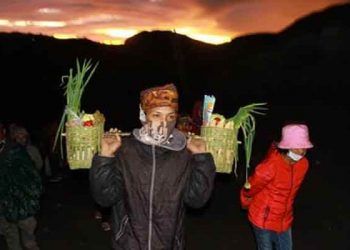 Warga tengger mengenakan masker dan membawa sayuran untuk dilarung dalam rangkaian kasada. Foto: bayu eka novanta/tugumalang.id