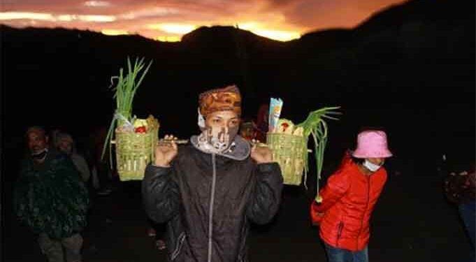 Warga tengger mengenakan masker dan membawa sayuran untuk dilarung dalam rangkaian kasada. Foto: bayu eka novanta/tugumalang.id