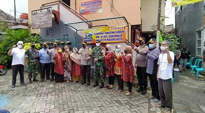 Kapolresta Malang Kota Kombes Pol Leonardus Simarmata menunjukkan bendera zonasi hijau di RW 1 Kelurahan Sukoharjo, Klojen, Kota Malang, Sabtu (13/2/2021). Foto : Azmy