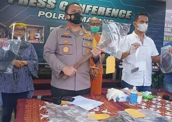 Kapolres Malang memegang cangkul sebagai barang bukti kasus pembunuhan