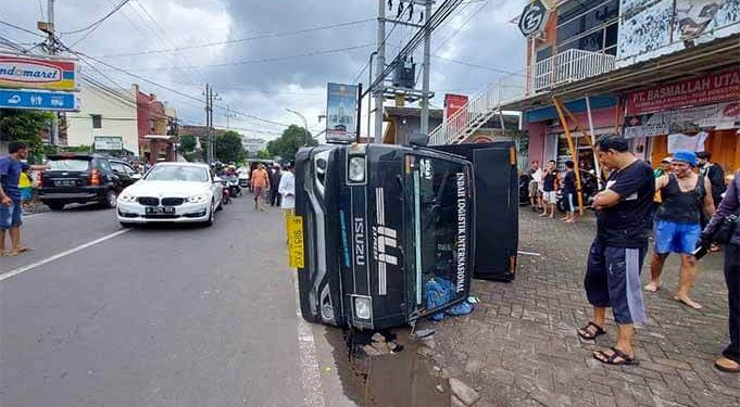 Mobil box terguling setelah terjadi laka lantas di Jalan Mayjen Panjaitan Kota Malang.