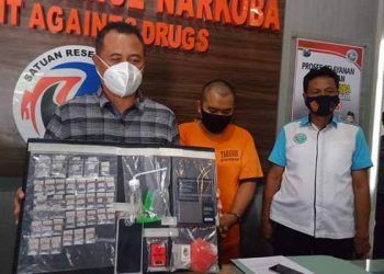 Kasat Narkoba Polres Malang menunjukkan barang bukti, dan tersangka (tengah).(foto: Rizal Adhi Pratama).