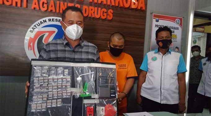 Kasat Narkoba Polres Malang menunjukkan barang bukti, dan tersangka (tengah).(foto: Rizal Adhi Pratama).