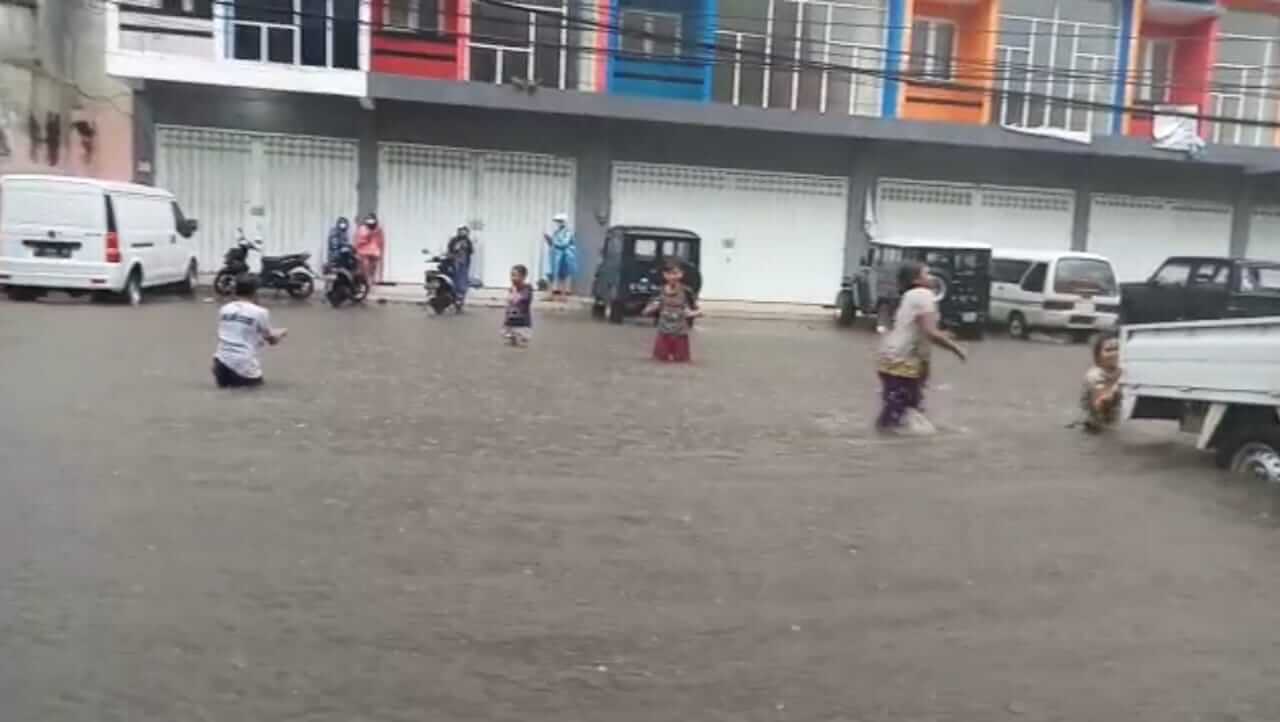 Anak-anak memanfaatkan banjir di kawasan Jalan Kedawung, Kota Malang berenang gratis, Senin (22/3/2021). Foto : Azmy