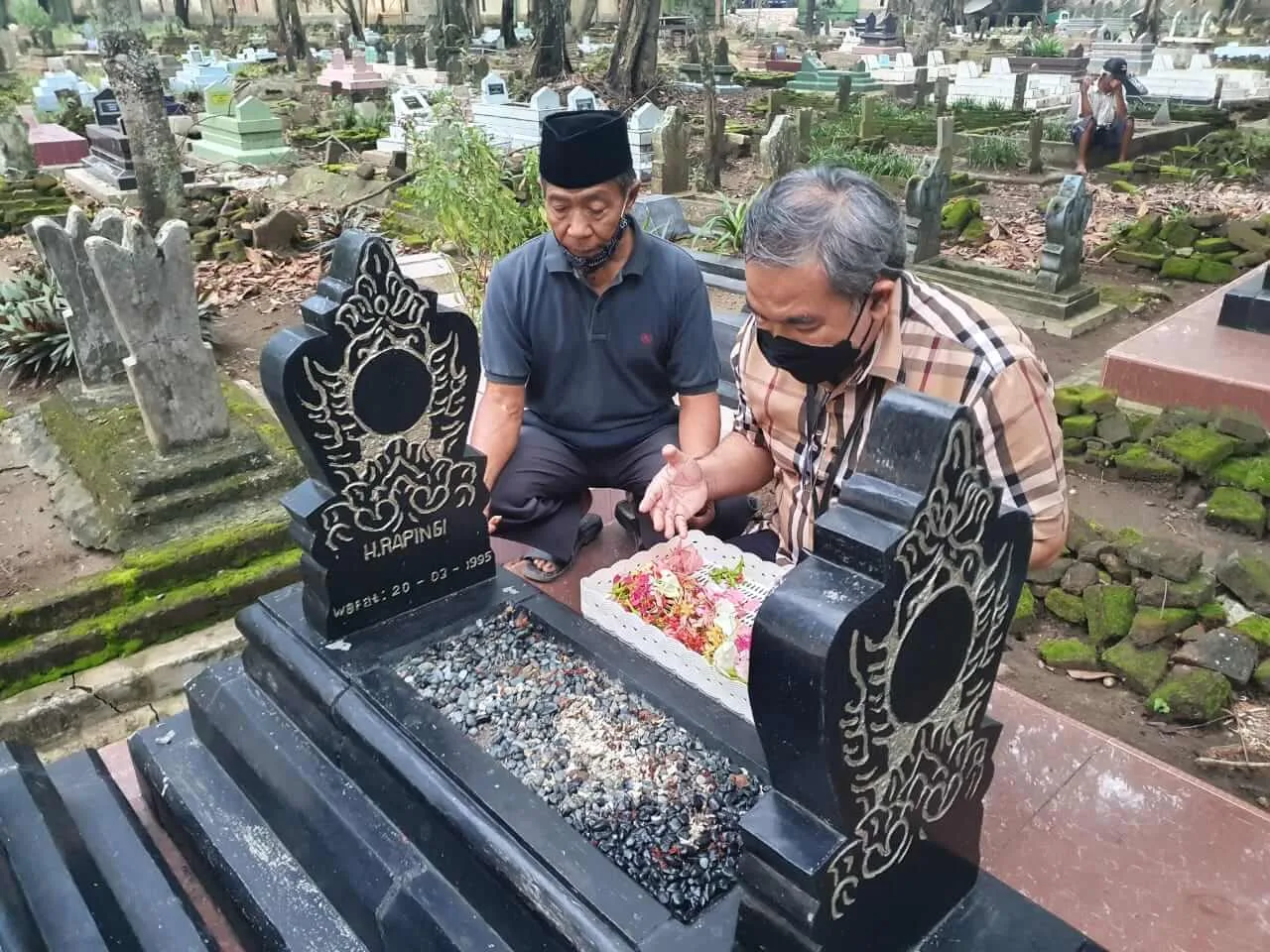 Pakar Komunikasi dan Motivator Nasional Dr Aqua Dwipayana didampingi Chudori di makam almarhum Rapingi. (Foto dok)