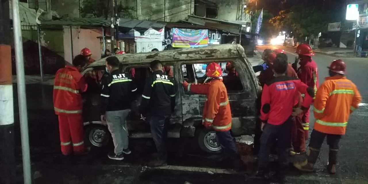Anggota UPT Damkar Kota Malang tengah memadamkan api di sebuah mobil yang terbakar di Jalan Raya Bandulan Kota Malang, pada Sabtu (3/4/2021). Foto: UPT Damkar Kota Malang