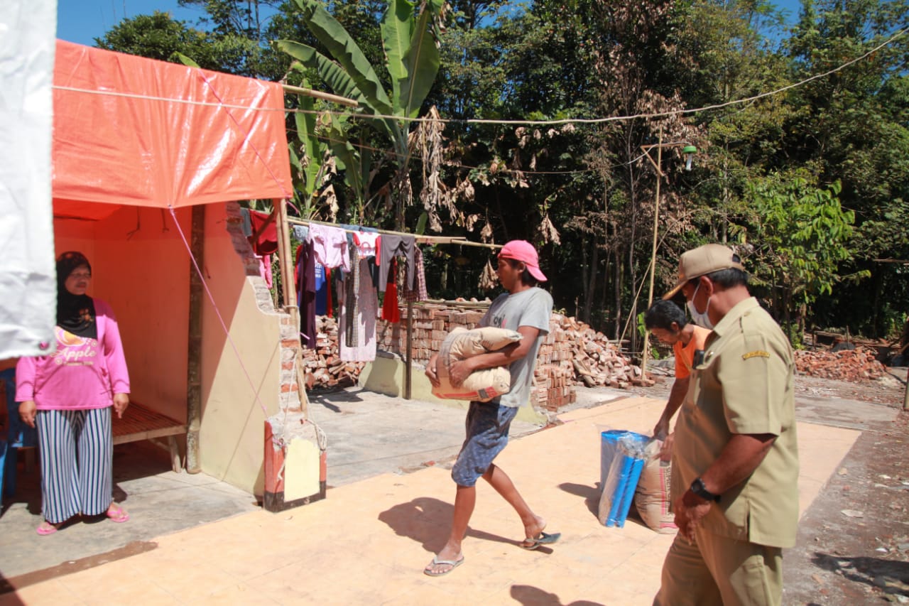 Relawan mengangkat bantuan semen untuk warga di dusun krajan, Desa Majang Tengah, Dampit. Foto: Bayu Novanta