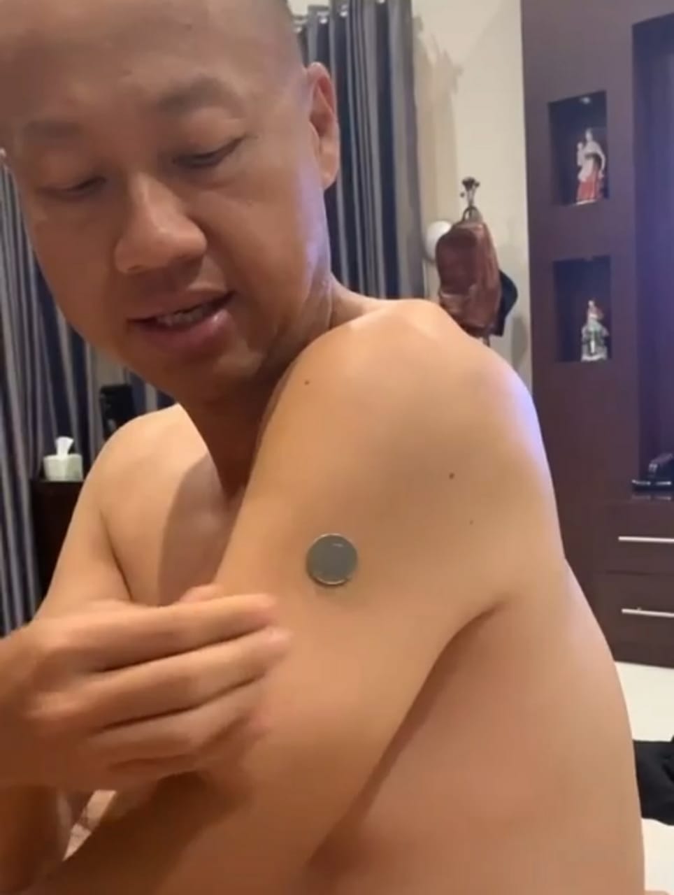 Seorang notaris di Kota Malang, Paulus Oliver Yoesoef, mencoba menempelkan uang koin di bekas suntikan vaksin Corona pada lengannya, dan berhasil. Foto: tangkapan layar