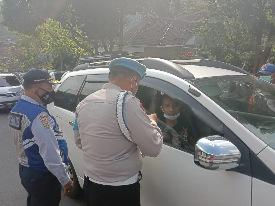 Foto 1: Petugas memeriksa syarat perjalanan dan meminta keterangan terkait keperluan perjalanan. Foto: Sholeh.