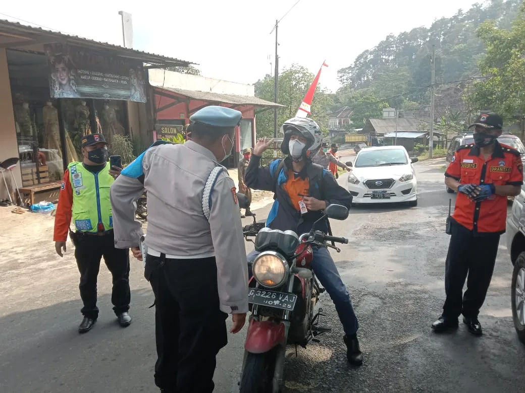 Petugas Polres Batu melakukan pemeriksaan pengendara yang memasuki wilayah Kota Batu. Foto: Sholeh.