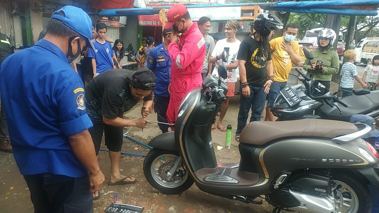 Proses evakuasi ular yang bersembunyi di dalam motor pengendara di Jalan Raya Gadang 1A Kota Malang, pada Selasa (22/6/2021). Foto: Damkar Kota Malang