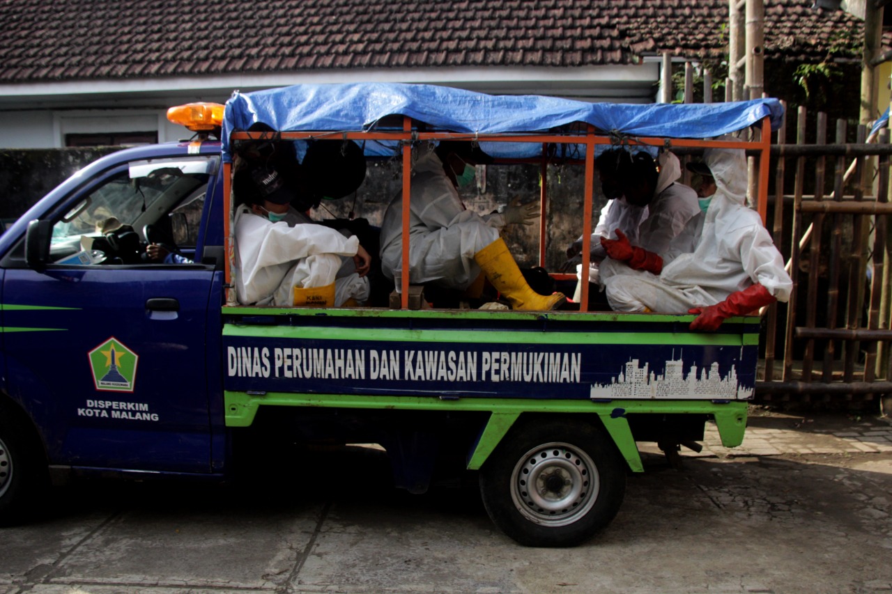 Di atas mobil sempit, para petugas berangkat menuju tempat pemakaman. (Foto: Rubianto/Tugu Malang/Tugu Jatim)