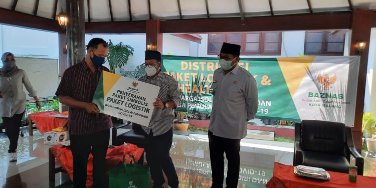 Proses penyerahan secara simbolis paket bantuan logistik dari Wali Kota Malang, Sutiaji, untuk warga isoman di Kota Malang. Foto: Ulul Azmy