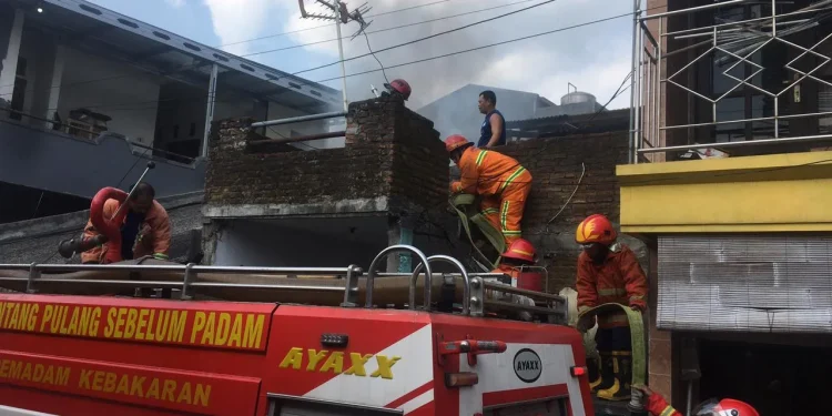 Proses pemadaman api oleh Damkar Kota Malang di sebuah rumah di Jalan Sanan Gang 2 Kelurahan Purwantoro, Kecamatan Blimbing, Kota Malang, pada Kamis (29/7/2021). Foto: Damkar Kota Malang