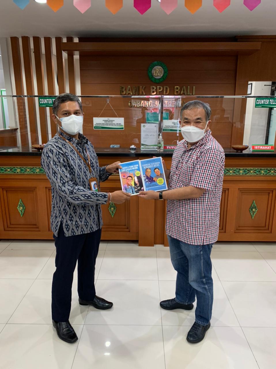 Kepala Dinas Perdagangan Provinsi Nusa Tenggara Barat Fathurrahman (kiri) saat menerima buku Trilogi The Power of Silaturahim dari Aqua Dwipayana. dok/istimewa