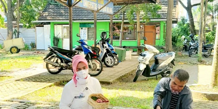 Rektor Universitas Gajayana Prof. Dr. Dyah Sawitri, SE, MM, saat turut membungkus daging kurban.
