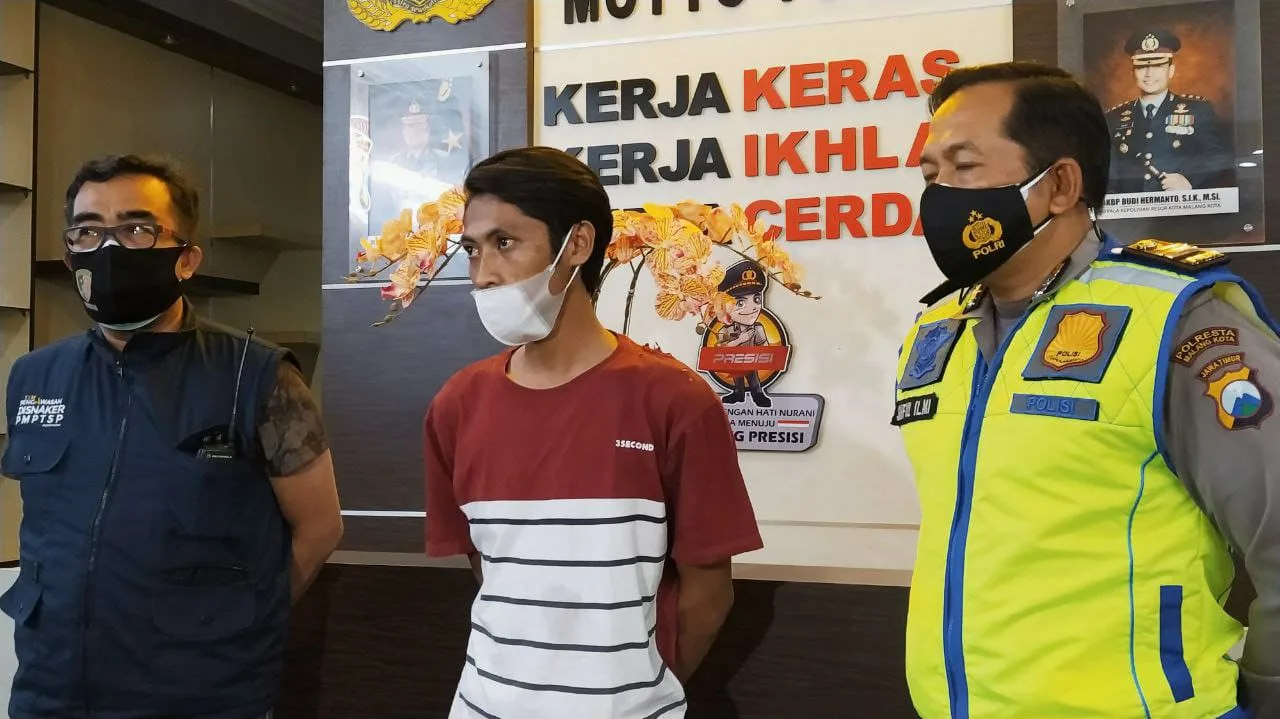 Aji Prasetyo Utomo (23), pelaku hoax korban laka akibat pemadaman lampu jalan di Malang saat memberikan klarifikasi di Mapolresta Malang Kota, Senin (6/7/2021) malam. Foto/Azmy.