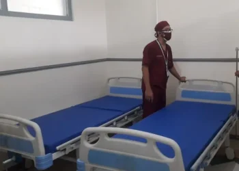 Seorang petugas menyiapkan tempat tidur untuk isoter