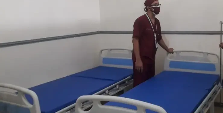 Seorang petugas menyiapkan tempat tidur untuk isoter