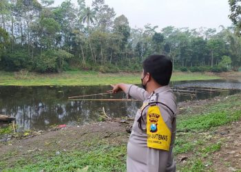 Petugas menunjukkan lokasi tenggelamnya seorang warga di Waduk Selorejo, Supiturang, Desa Sumberagung, Kecamatan Ngantang, Kabupaten Malang, pada Kamis (5/8/2021). Foto: Ulul Azmy