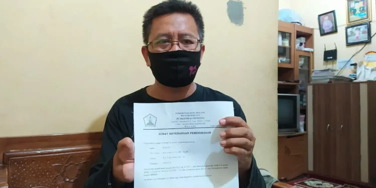 Sunoto (35) saat menunjukkan surat keterangan sehat dari COVID-19. Foto: Ulul Azmy
