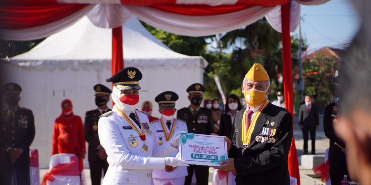 Wali Kota Batu, Dewanti Rumpoko, memberikan insentif kepada Ketua Legiun Veteran Republik Indonesia (LVRI) Kota Batu, Handri Israwan, usai upacara HUT ke-76 RI, pada Selasa (17/8/2021). Foto: Ulul Azmy