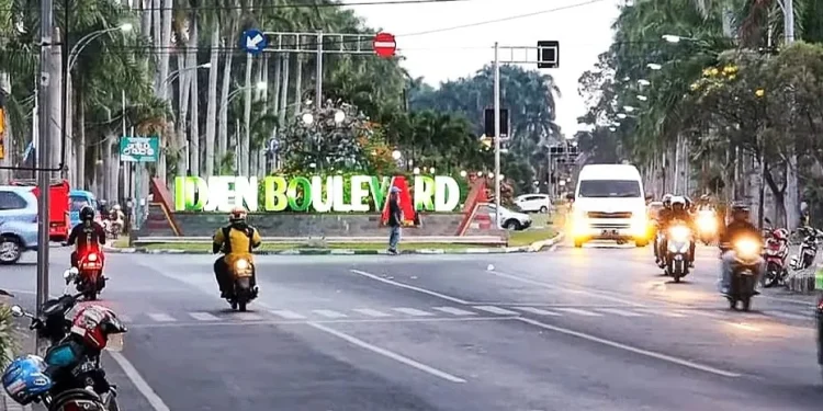 Suasana jalan Idjen Kota Malang di sore hari tampak sejuk dan ramai kendaraan/tugu malang