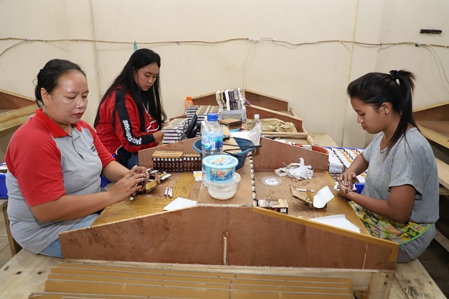 Tiga pekerja sedang membuat rokok saat petugas gabungan melakukan sidak rokok ilegal di Kota Malang/tugu malang