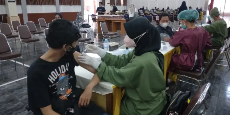 Nakes melakukan vaksinasi COVID-19