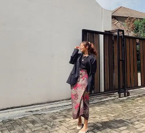Penyanyi Nadin Amizah memadukan bawahan kain batik, dengan kaos dan blazer sebagai outer serta ditambah multi layer necklace/tugu malang