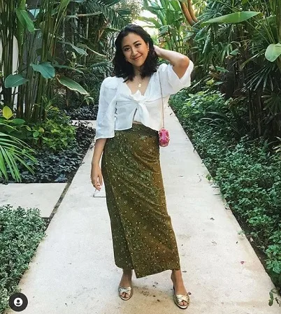 Penyanyi cilik Sherina Munaf mengenakan memadukan blouse putih dengan bawahan kain batik hijau dan heels/tugu malang