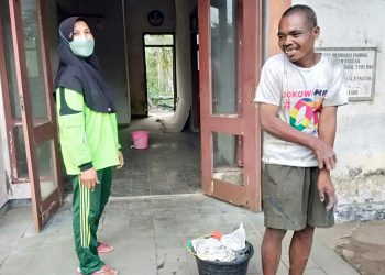 Murwati Handayani, relawan ODGJ, ketika menyambangi Bambang, ODGJ yang tinggal di gedung tua di depan SMAN Punung Kabupaten Pacitan. (Foto: Risma Wigati/Tugu Malang)