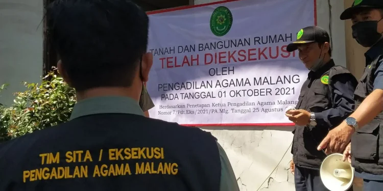 Juru sita Pengadilan Agama Malang saat eksekusi riil (pengosongan) sebuah rumah senilai Rp 1,9 miliar hasil sengketa waris di Kota Batu, pada Jumat (1/10/2021). Foto: Ulul Azmy