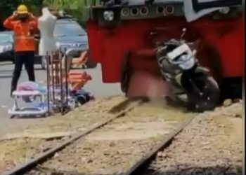 Kereta api menggilas sepeda motor yang parkir sembarangan di atas rel. Foto: tangkapan layar video viral