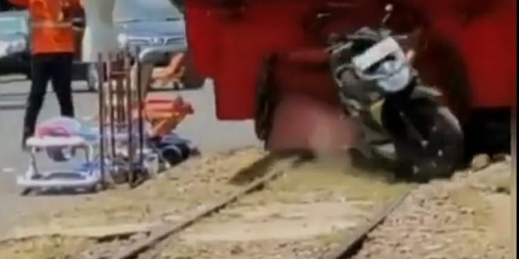 Kereta api menggilas sepeda motor yang parkir sembarangan di atas rel. Foto: tangkapan layar video viral