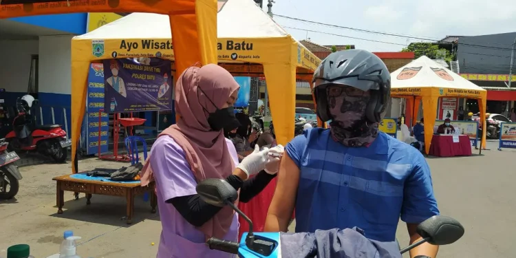 Polres Batu menggelar vaksinasi drive thru di Alun-Alun Kota Batu, Senin (11/10/2021). Masyarakat bisa mengakses vaksin lebih mudah, bahkan tanpa harus turun dari kendaraan. Foto/Azmy