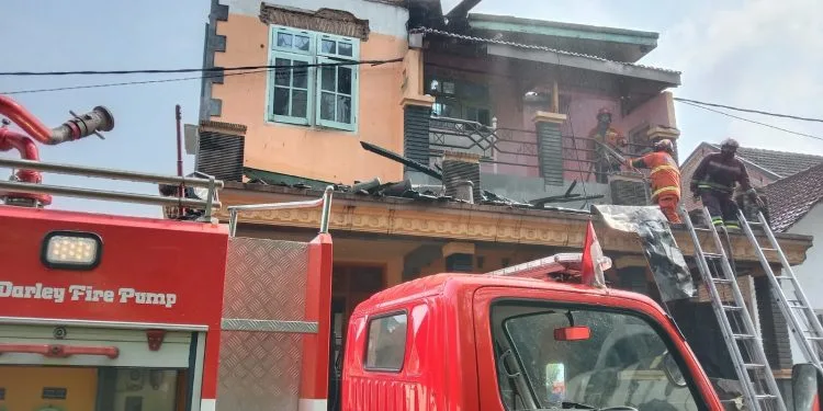 Petugas melakukan pendinginan setelah rumah pengusaha sepatu kebakaran