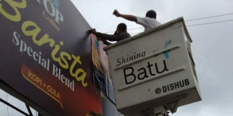 Proses penertiban reklame liar oleh Satpol PP Kota Batu dan Dinas Penanaman Modal Perizinan Terpadu Satu Pintu dan Tenaga Kerja (DPMPTSP-TK). Foto: Satpol PP Kota Batu