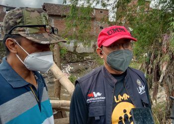 Koordinator UMM Berbagi, Zakaria Ahmad dan Ketua RW06 Kelurahan Jodipan, Muhammad Lutfi saat berada di lokasi terdampak banjir bandang. Foto: M Sholeh