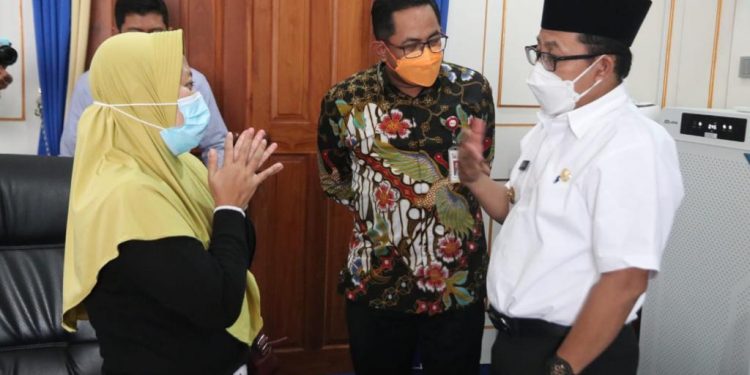 Kepala OJK Malang Sugiarto Kasmuri (tengah) bersama Wali Kota Malang Sutiaji (kanan) saat mengunjungi korban pinjol di Malang. Foto/OJK Malang.