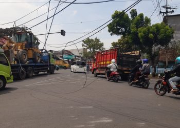 kabel melintang di atas jalan di Bululawang akibat diterjang truk pengangkut buldoser.