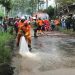 Petugas BPBD Kota Batu melakukan pembersihan lumpur di jalan Abdul Gani