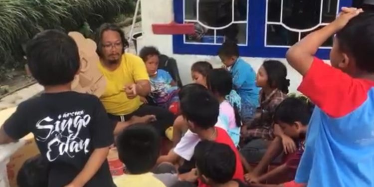 Aksi jurnalis sekaligus pegiat literasi, Bahana Patria Gupta, saat bercerita kepada anak-anak pengungsi lewat media boneka kardus bikinannya. (Foto: Dokumen)