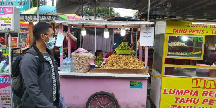Sejumlah wisatawan di Kota Batu tetap memakai masker saat menyambangi pusat jajanan di Alun-alun Kota Batu. Foto: Ulul Azmy