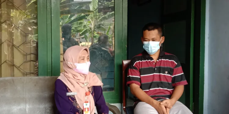 Kepala Dinsos-P3AP2KB Kota Malang, Penny Indriani (kiri) menjenguk dan memberikan bantuan sembako kepada Joko Santoso. Foto: M Sholeh